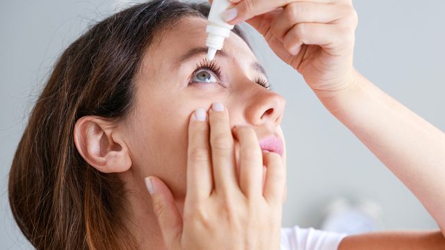 Young,Woman,Putting,Eye,Drops,At,Home
