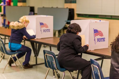 Women voters at polls during presidential election, paper ballots.