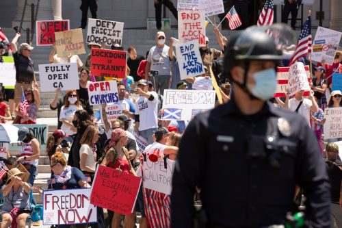 People in front of Los Angeles' City Hall protest the state's COVID-19 stay at home orders in a 