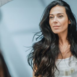 Woman is looking at the mirror.