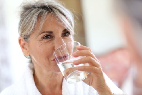 Senior woman drinking water in the morning.