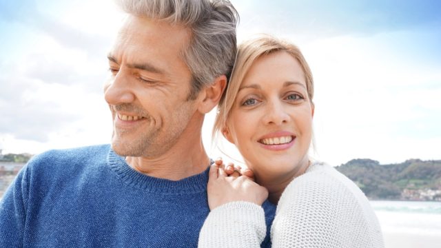 Middle-aged couple embracing each other at the beach