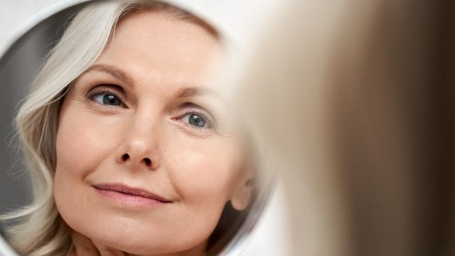 Middle-aged woman looking in the mirror.