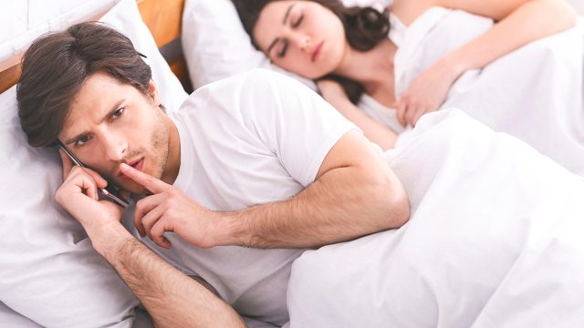 Man,Cheater,Talking,Privately,On,Cellphone,In,Family,Bed,,Cheating