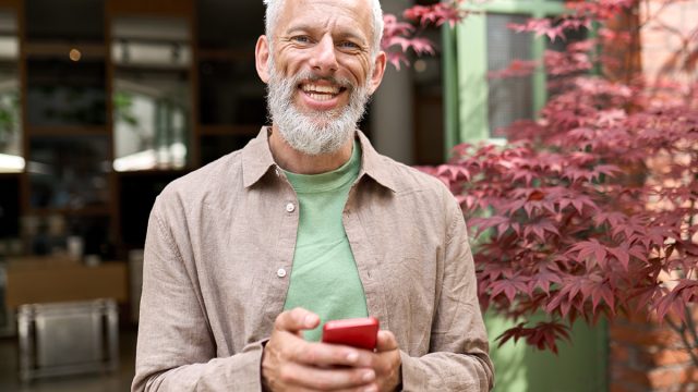 Smiling,Gray haired,Older,Middle,Aged,Bearded,Man,Using,Mobile,Phone