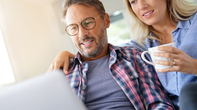 Mature,Couple,Connected,On,Internet,With,Laptop