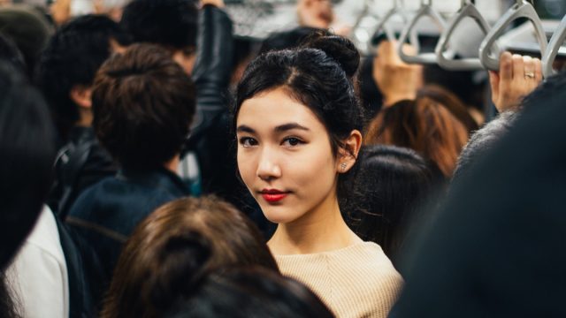 Asian woman in the crowded subway car.