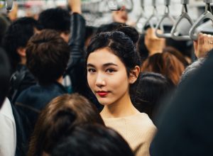 Asian woman in the crowded subway car.
