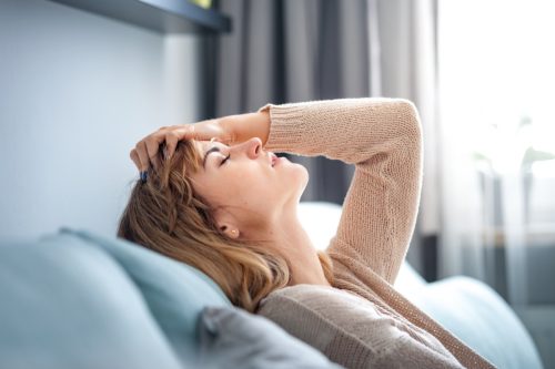 Woman sitting on sofa at home.