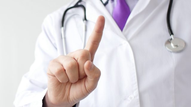 Medical doctor making negative sign for medicine by his finger.