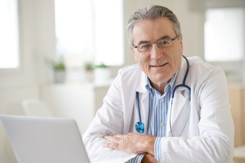 Portrait of senior doctor sitting in medical office