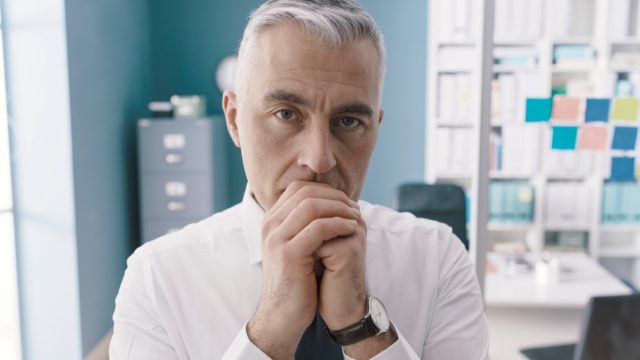Businessman standing in his office and thinking.