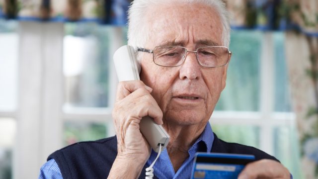 Senior Man Giving Credit Card Details On The Phone