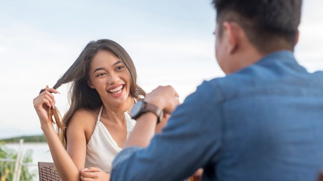 Body Language, Attraction,A,Young,Woman,Twirls,Her,Hair,While,Listening,Intently,To
