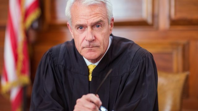 Judge sitting behind judges bench in court