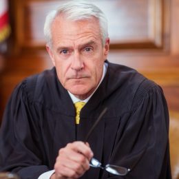 Judge sitting behind judges bench in court