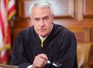 Judge sitting behind judges bench in court