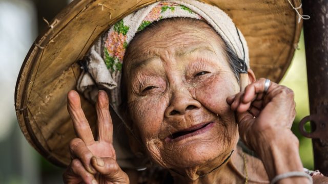 PHOP PHRA, TAK, THAILAND - MARCH 08, 2017 : Unidentified Asian woman very old aged is showing hand V-sign with a happy face at Phop Phra, Tak, Thailand.