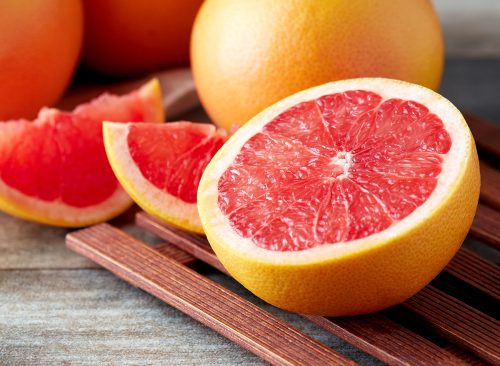 Fresh raw grapefruit (citrus x paradisi) on wooden background