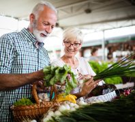 Mature couple shopping vegetables and fruits on the market. Healthy diet.