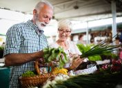 Mature couple shopping vegetables and fruits on the market. Healthy diet.