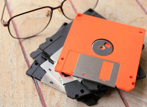 Close-up of the diskette for old computers being stacked on a wooden table selective focus and shallow depth of field