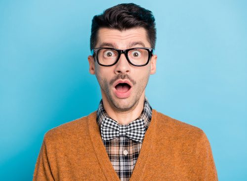 Photo of astonished young man open mouth unbelievable information isolated on pastel blue color background