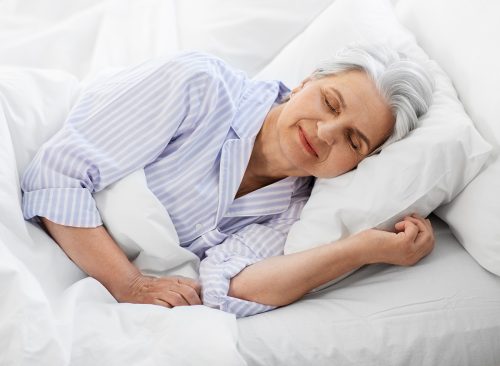 old age and people concept - senior woman sleeping in bed at home bedroom