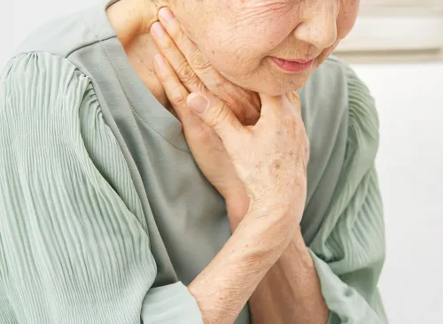 Asian senior woman having trouble breathing