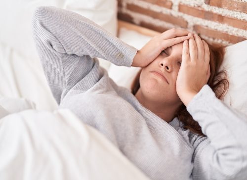 Young beautiful plus size woman stressed lying on bed at bedroom