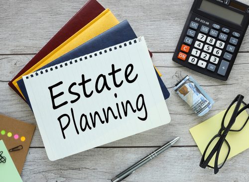 Estate Planning - text on a notepad, three notepads on the desktop. conceptual background