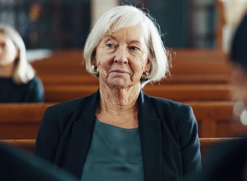 Funeral, church and senior woman for ceremony, sermon and memorial service for death, mourning and loss. Religion, chapel and sad elderly female person in congregation for comfort, memory and prayer