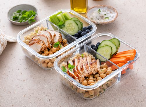 Meal prep containers with healthy high protein food prepped, cooked quinoa, chickpeas and eggs