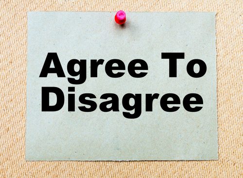 Agree To Disagree written on paper note pinned with red thumbtack on wooden board. Business conceptual Image