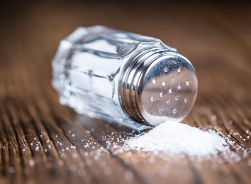 Old wooden table with a Salt Shaker (close-up shot; selective focus)