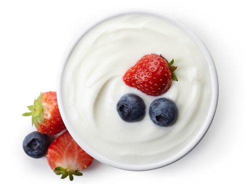 Bowl of greek yogurt and fresh berries isolated on white background from top view