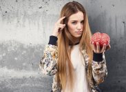 pretty young woman holding a brain object