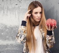 pretty young woman holding a brain object