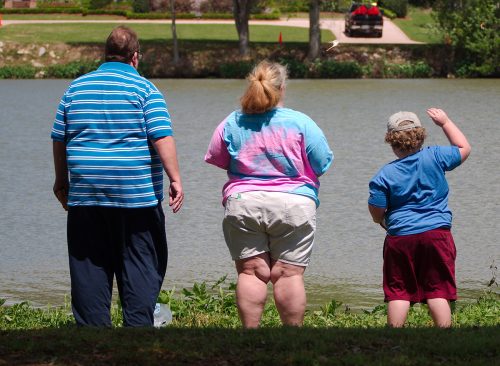 Obese family stands by University Lake near Louisiana State University.