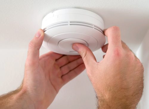 Man installing smoke or carbon monoxide detector