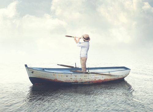 business man on a boat watching the future with binoculars