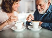 Happy senior couple sitting in coffeeshop, looking at each other. Romantic date for elderly couple in love.